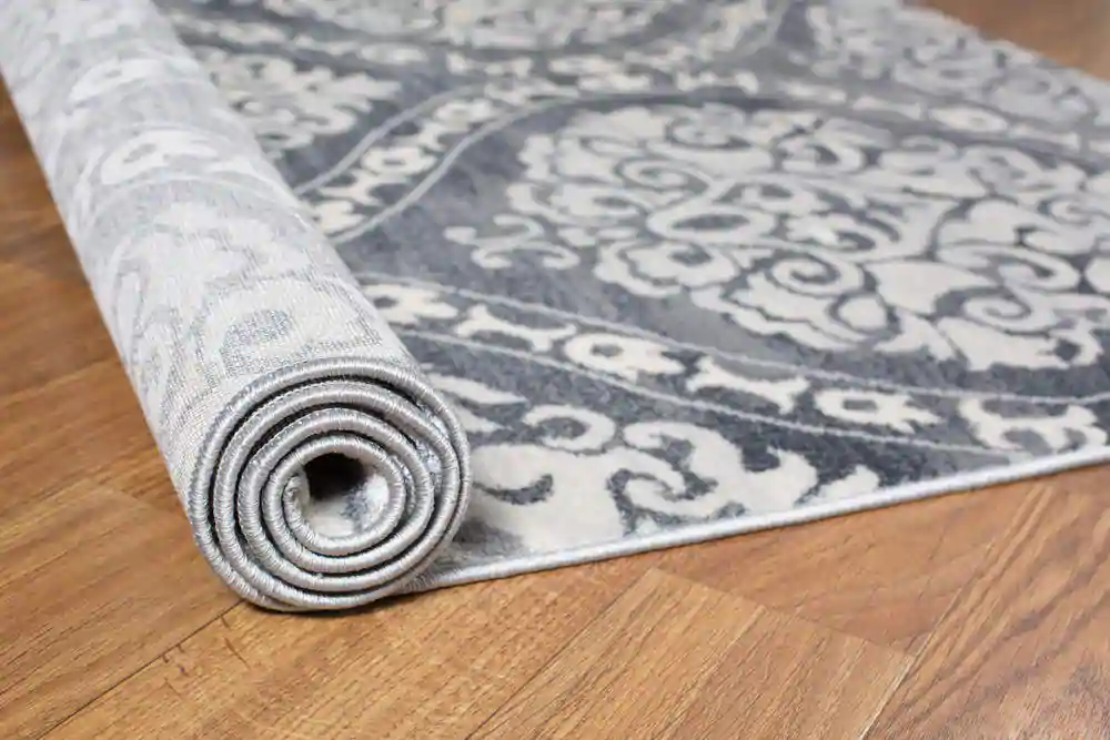 A grey and white rug on a wooden floor, adding warmth and style to the room's decor.