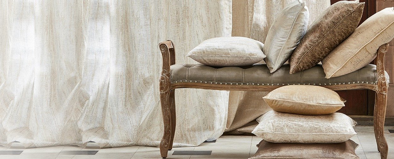 A chair with pillows and a curtain, creating a cozy and inviting atmosphere.