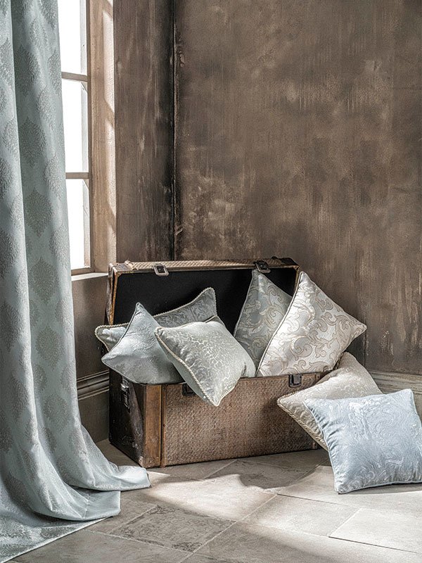 Pillows and curtains placed in front of a window, creating a cozy and inviting atmosphere.