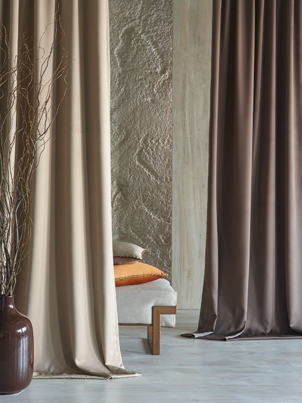 A room with a brown couch and a brown curtain.
