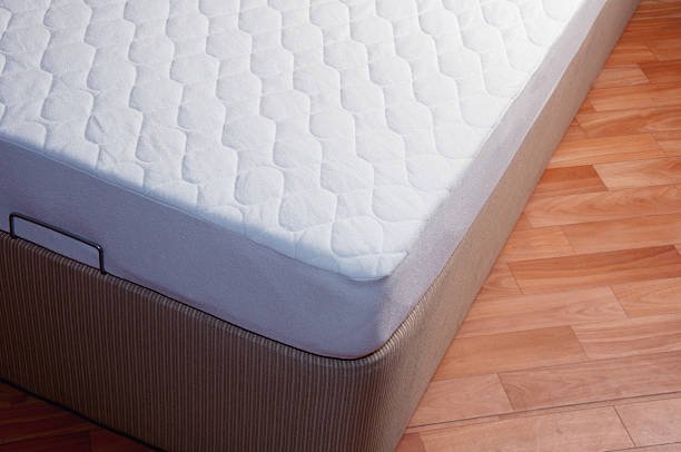 A comfortable mattress placed on a wooden floor.