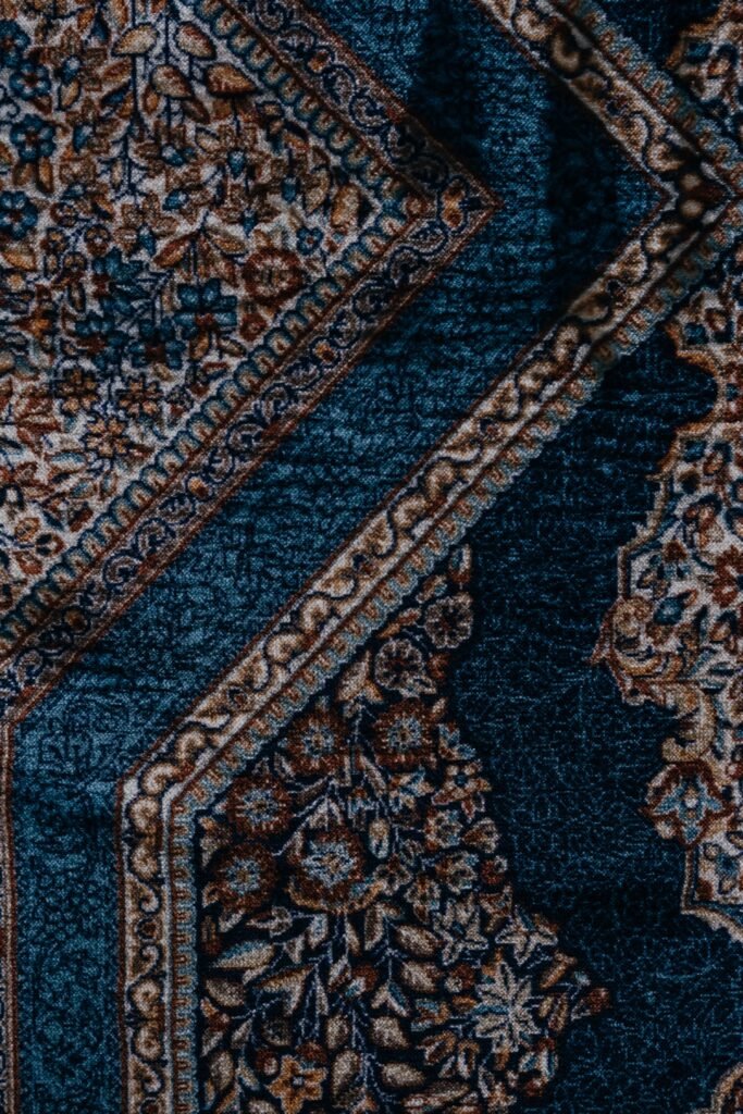 A decorative blue and brown rug with an intricate design, adding elegance to any room.