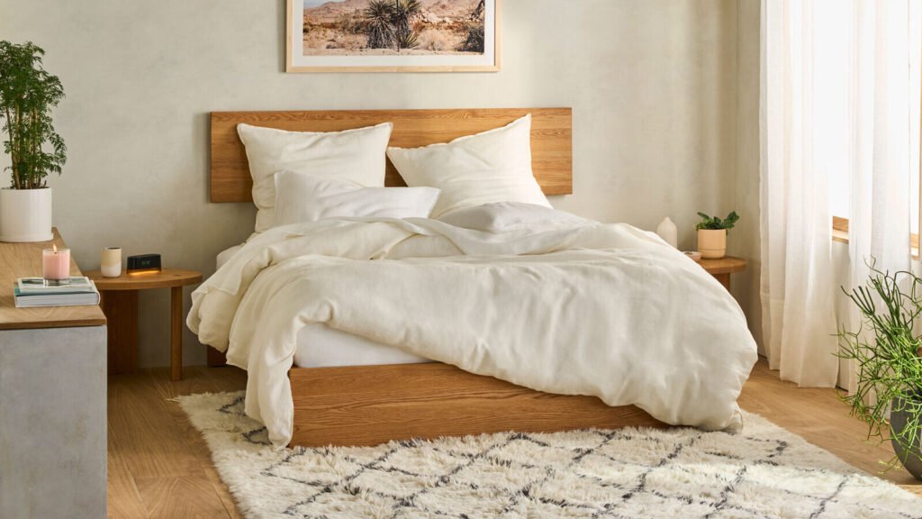 A cozy bedroom featuring a white bed with a wooden headboard and a white comforter.
