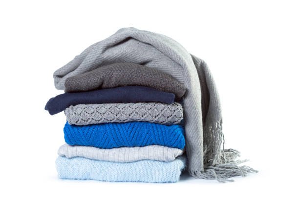 Folded woolen blankets arranged in a stack.