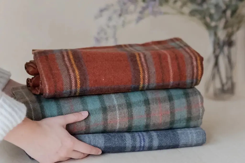 A stack of three blankets, providing warmth and comfort.