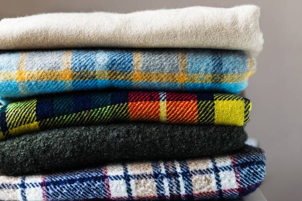 A stack of folded blankets, each in a different color.