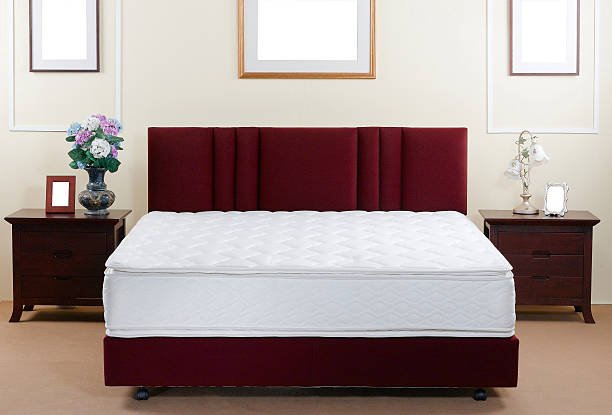 A stylish red bed with a comfortable mattress, perfectly arranged in a beautifully designed bedroom interior.