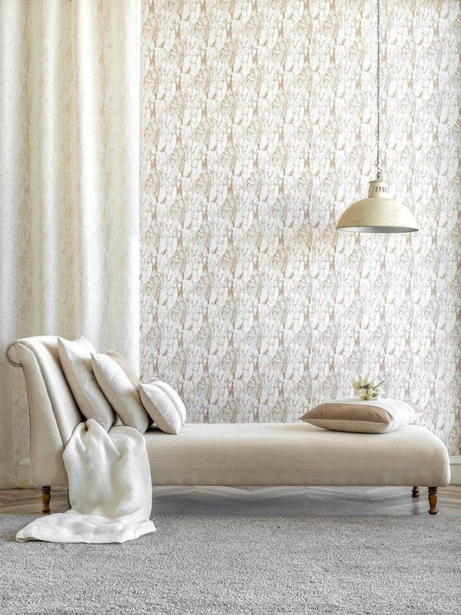 Elegant white chaise lounge in front of a designer wallpapered room.