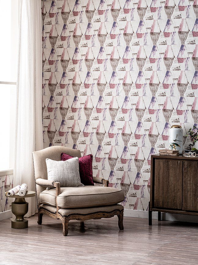 A stylish chair and table placed in a room with designer wallpapers in the background.