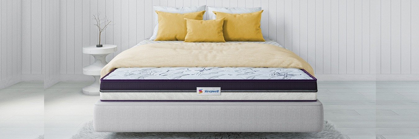 A comfortable mattress on a white bed frame.